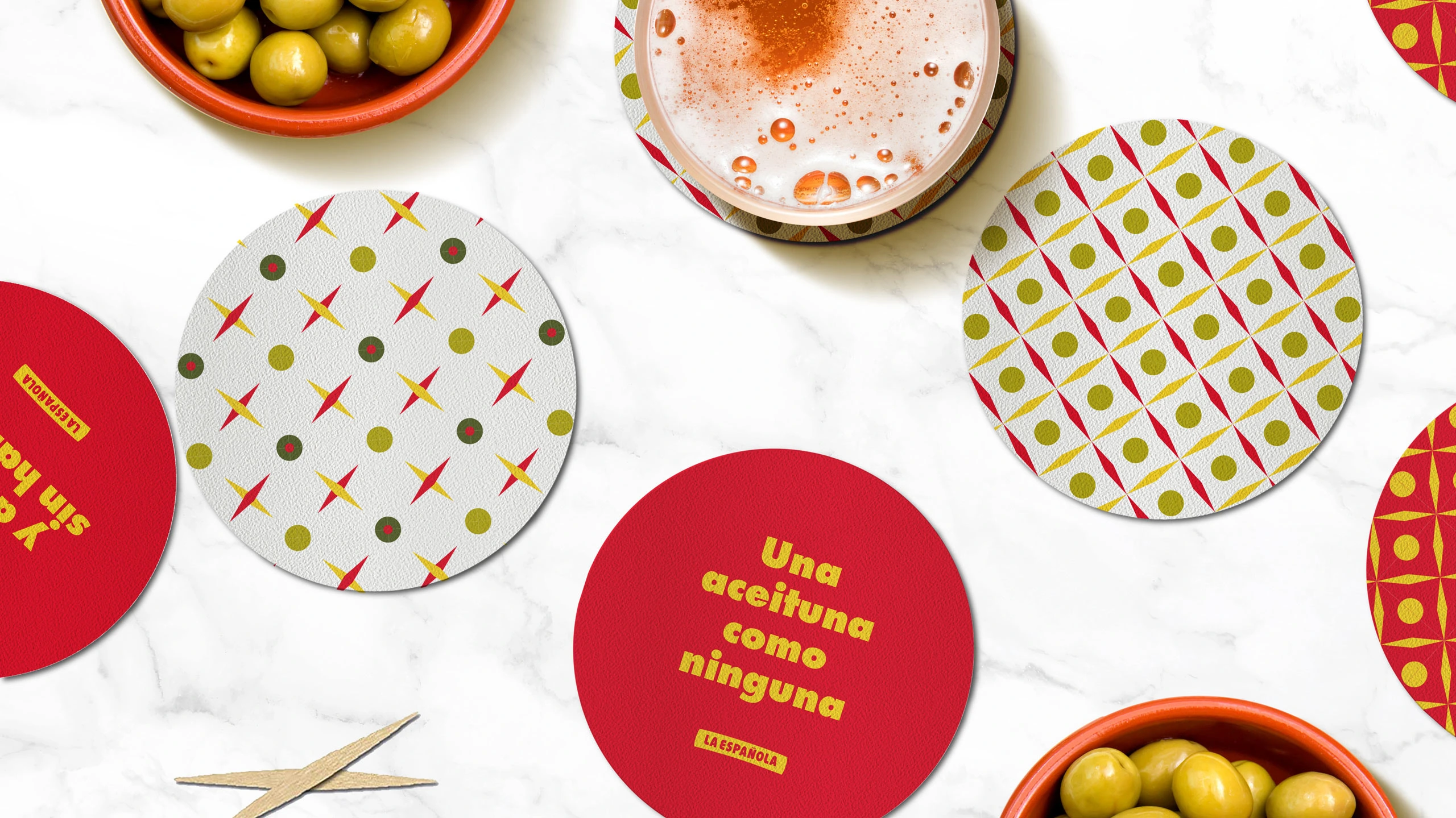 La Española coasters with different tile patterns on marble, olives and beer in the background