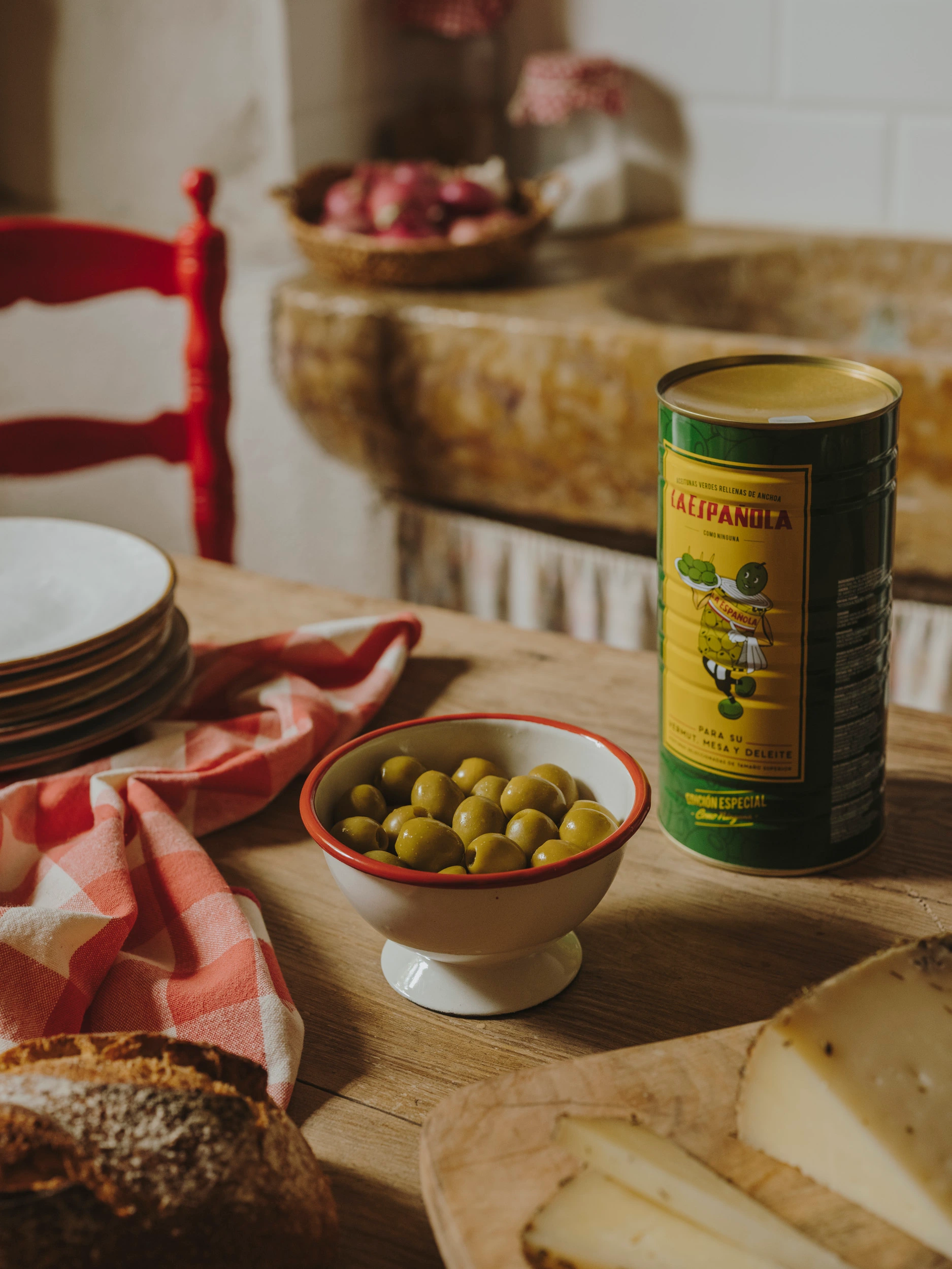Olives in ceramic bowl beside a vintage-style La Española tin