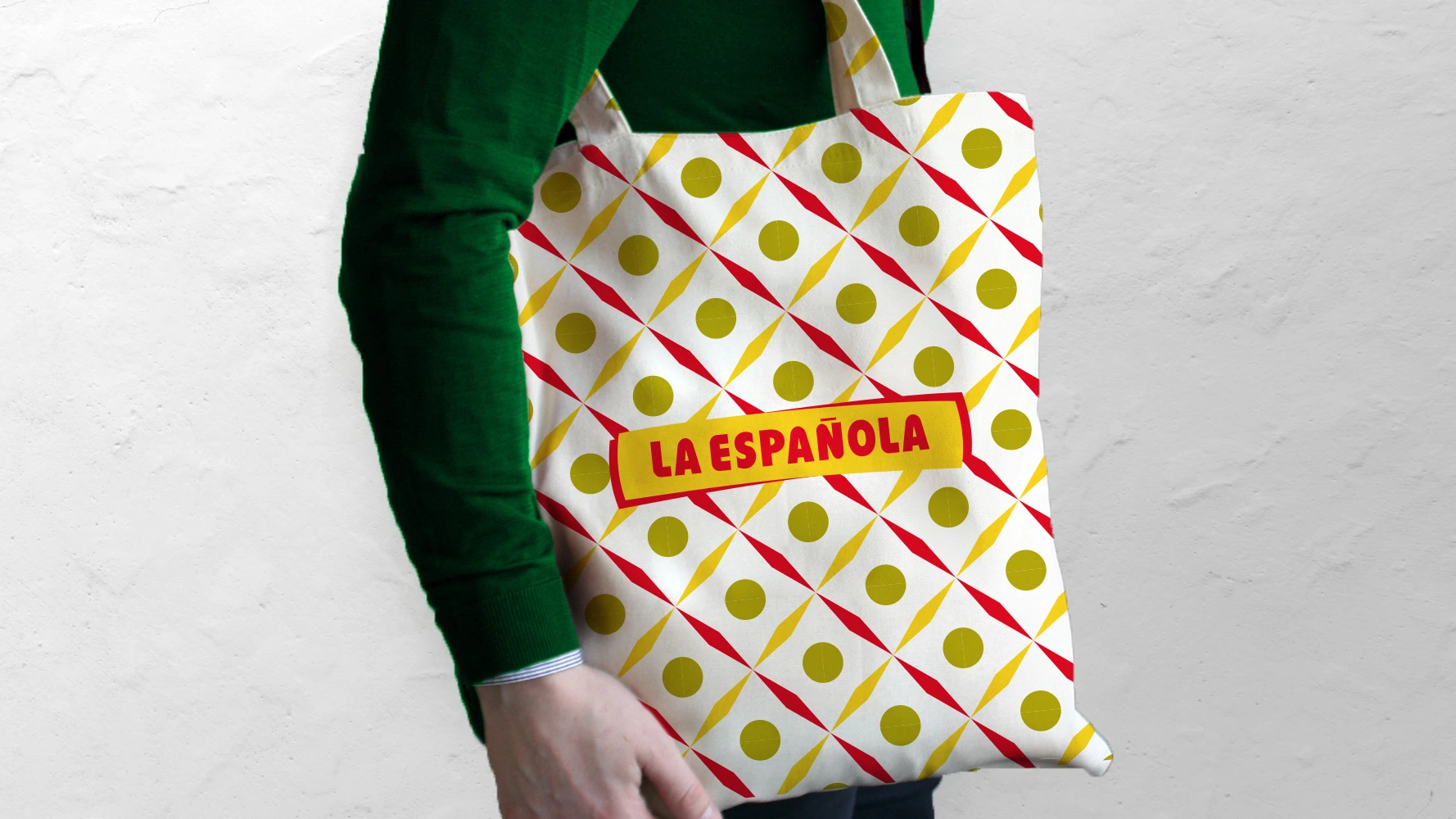 La Española branded tote bag held by a person in a green sweater